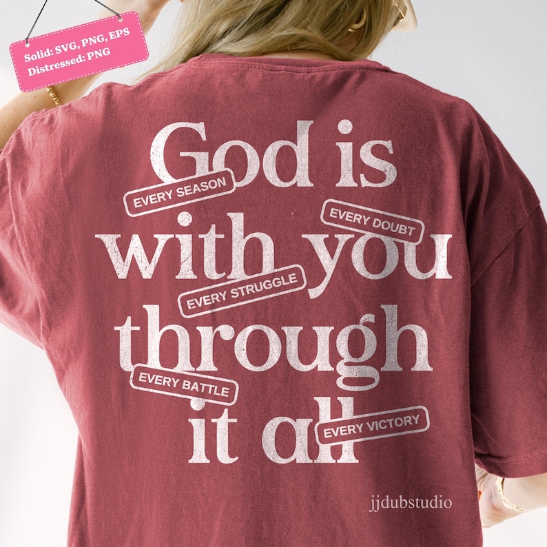 May include: A maroon t-shirt with the text "God is with you through it all." The text is in white, with the words "Every Season," "Every Struggle," "Every Doubt," "Every Battle," and "Every Victory" in smaller text.