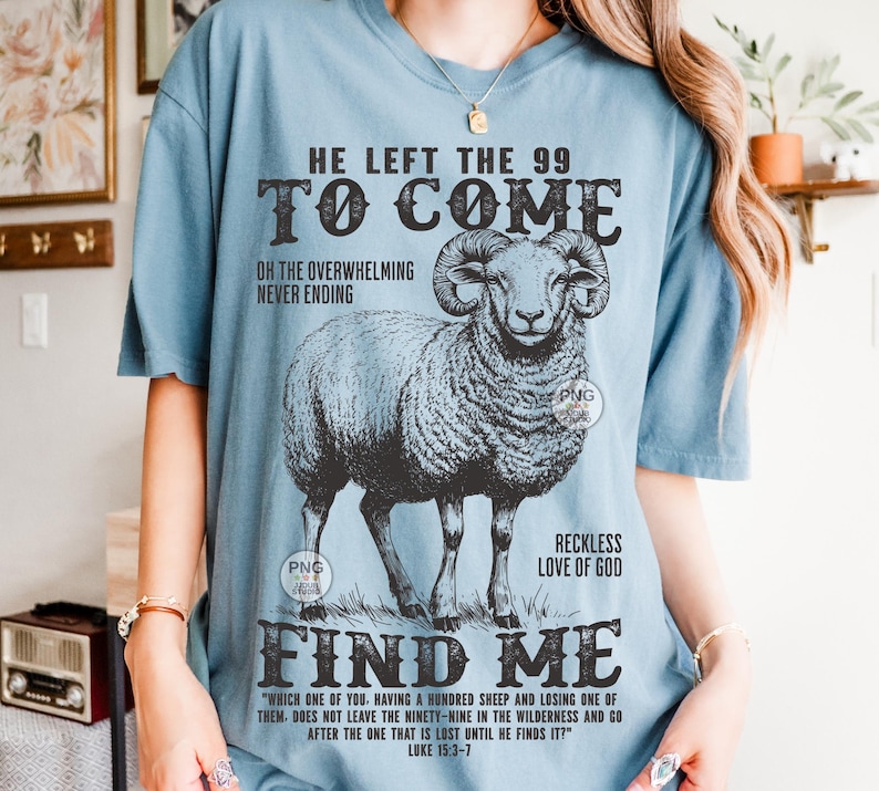 May include: A pale blue t-shirt with a detailed illustration of a ram. The shirt features the text "HE LEFT THE 99 TO COME" and "FIND ME", along with a quote from Luke 15:3-7. The design is in black and white.