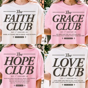 May include: Four t-shirts with the words "The Faith Club", "The Grace Club", "The Hope Club", and "The Love Club" printed in black. Each shirt has additional text below the club name. The shirts are cream and pink.