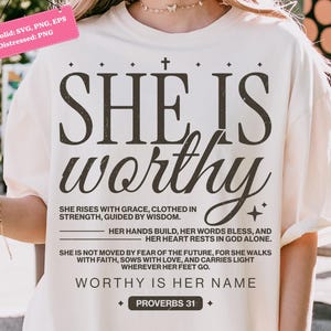 May include: Cream-colored t-shirt with the words "SHE IS worthy" in a bold, dark font. The shirt features additional text below, including "WORTHY IS HER NAME" and "PROVERBS 31". The design is a distressed PNG.
