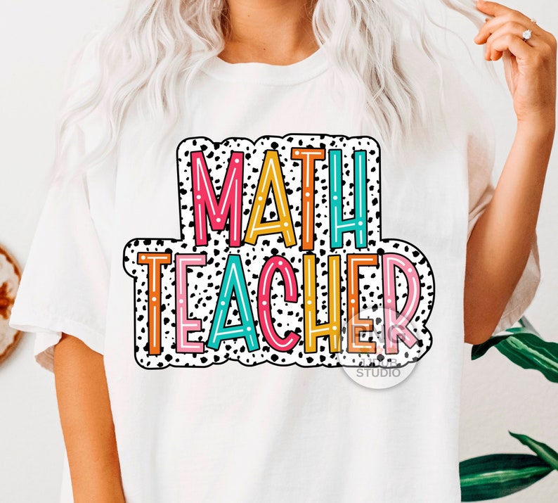 Op de afbeelding: Wit T-shirt met een kleurrijke afbeelding met de tekst "MATH TEACHER" in een zwart-wit stippenpatroon.