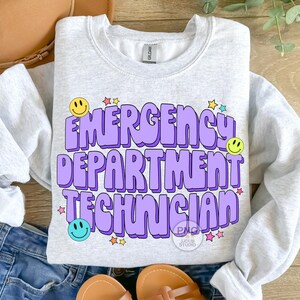 May include: A gray sweatshirt with a purple design that says "Emergency Department Technician" with smiley faces and stars.