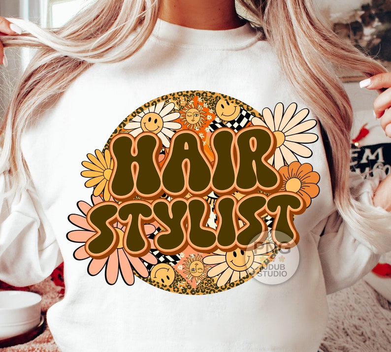 May include: White sweatshirt with a brown and orange retro-style graphic that says "Hair Stylist" surrounded by daisies and smiley faces.