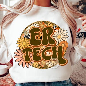 May include: White sweatshirt with a brown and yellow graphic design featuring the text "ER TECH" surrounded by flowers and other retro-style elements.