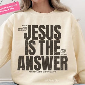 Może przedstawiać: Kremowa bluza z napisem "JESUS IS THE ANSWER" w postarzanym czarnym napisie. Dodatkowy tekst to "WHEN OUR STRENGTH RUNS OUT", "WHEN PEACE FEELS DISTANT" i "WHEN LIFE GETS OVERWHELMING".