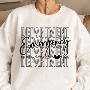 Może przedstawiać: Biała bluza z czarnym napisem "DEPARTMENT Emergency DEPARTMENT" z małym czarnym sercem w środku słowa "Emergency".