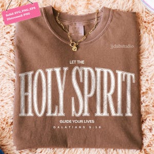 May include: A brown Comfort Colors sweatshirt with the text "LET THE HOLY SPIRIT GUIDE YOUR LIVES" in white. A gold chain necklace with a pendant rests on the shirt. The text "GALATIANS 5:16" is at the bottom.