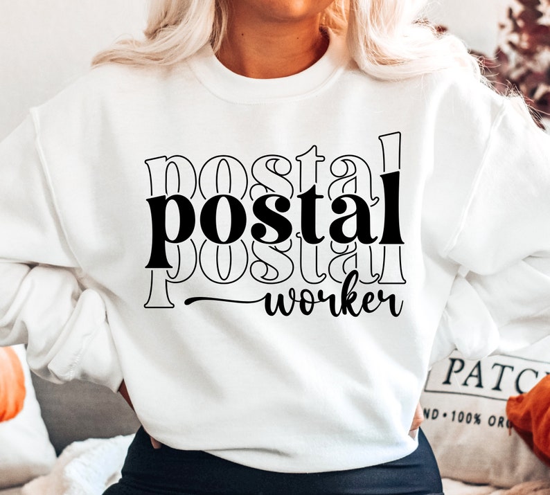 May include: White sweatshirt with black text that reads "postal worker" in a layered, stacked font style.