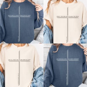 Könnte beinhalten: Vier Oberteile in verschiedenen Farben, jeweils mit einem Kreuz-Design und einem religiösen Zitat. Die Zitate lauten: "Nichts ist unmöglich mit Gott", "Vertraue dem, der die Meere beruhigt", "Alles, was ihr tut, geschehe in Liebe" und "Seine Gnade ist jeden Morgen neu."