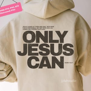 May include: A beige hoodie with the text "ONLY JESUS CAN" in dark brown, distressed lettering. The back of the hoodie also features a Bible verse and the words "jjdubstudio".