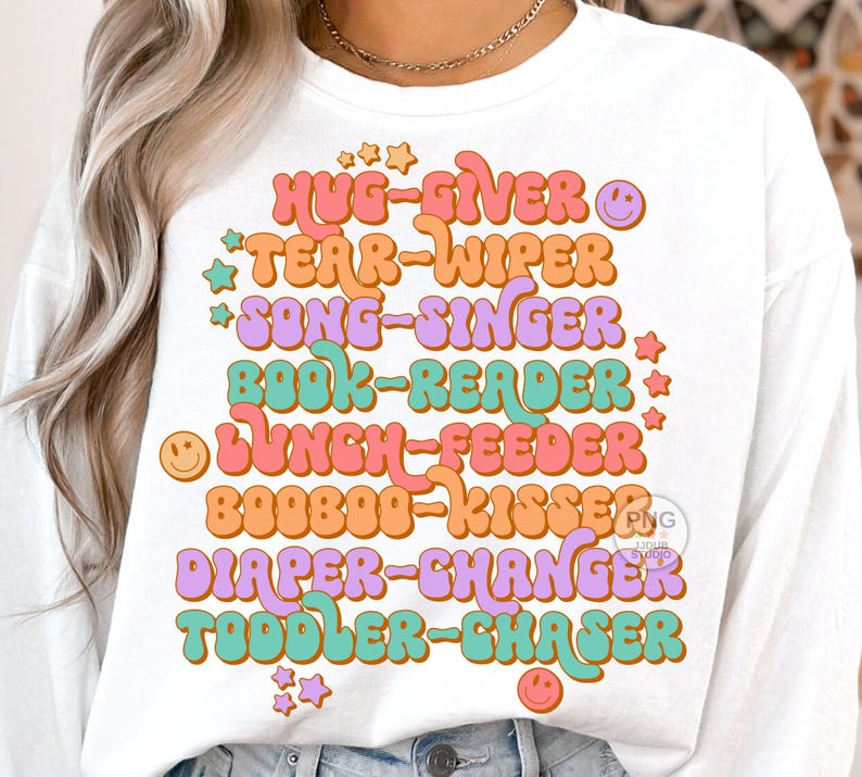 Peut inclure: T-shirt &agrave; manches longues blanche avec un graphique r&eacute;tro color&eacute; qui dit "Hug-Giver, Tear-Wiper, Song-Singer, Book-Reader, Lunch-Feeder, Booboo-Kisser, Diaper-Changer, Toddler-Chaser".