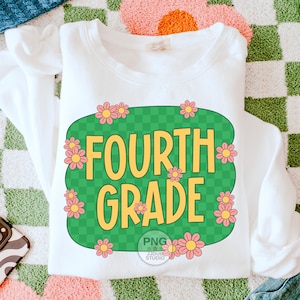 May include: White sweatshirt with a green and white checkered design featuring the text "FOURTH GRADE" in yellow letters and pink flowers around the design.
