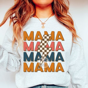May include: A gray sweatshirt with the text "MAMA" repeated four times in different colors and a checkered lightning bolt graphic. The text is in a retro font style.