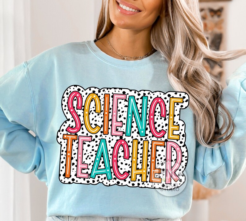 Peut inclure: Sweat-shirt bleu clair avec un motif de pois noirs et blancs et le texte "SCIENCE TEACHER" en lettres color&eacute;es.