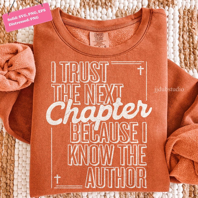 以下が含まれることがあります： 「I TRUST THE NEXT Chapter BECAUSE I KNOW THE AUTHOR」の白文字がプリントされた、錆色のスウェットシャツ。クルーネックと長袖のデザイン。Comfort Colorsブランドのタグが見えます。