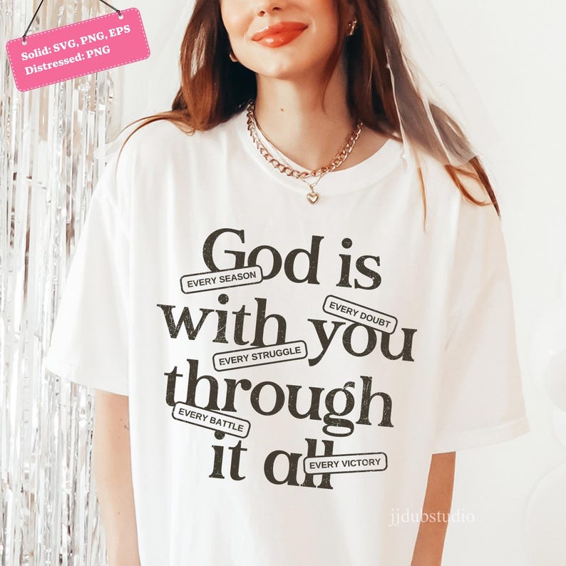 May include: White t-shirt with the message "God is with you through it all" in black text. The design includes the phrases "Every Season," "Every Doubt," "Every Struggle," "Every Battle," and "Every Victory."