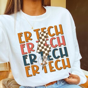 May include: White sweatshirt with a checkered lightning bolt graphic and the text "ER TECH" repeated four times in different colors.