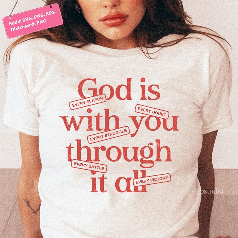 May include: A white t-shirt with the words "God is with you through it all" in red lettering. The design includes the phrases "Every Season," "Every Doubt," "Every Struggle," "Every Battle," and "Every Victory."