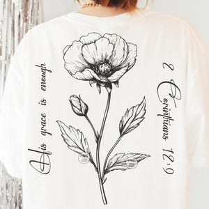 Peut inclure: T-shirt blanc avec une illustration en noir et blanc d'une fleur et le texte "Sa gr&acirc;ce suffit 2 Corinthiens 12:9"