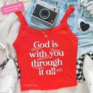 May include: A red tank top with the text "God is with you through it all" in white. The top is paired with denim shorts, a camera, sunglasses, and a necklace. The tank top has the words "Every Season, Every Doubt, Every Struggle, Every Battle, Every Victory".