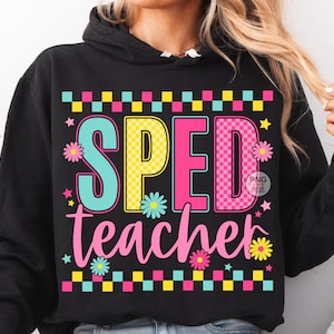 May include: Black hooded sweatshirt with the words "SPED teacher" in colorful block letters and a floral design. The letters are teal, yellow, and pink, with a checkered pattern above and below the text.