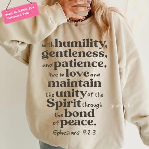 以下が含まれることがあります： ベージュのスウェットシャツ。テキスト「with humility, gentleness, and patience, live in love and maintain the unity of the Spirit through the bond of peace. エペソ人への手紙4:2-3」が濃いグレーでプリントされています。クルーネック、長袖です。