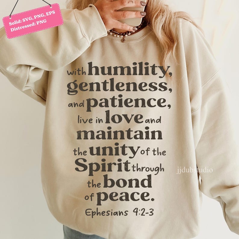 以下が含まれることがあります： ベージュのスウェットシャツ。テキスト「with humility, gentleness, and patience, live in love and maintain the unity of the Spirit through the bond of peace. エペソ人への手紙4:2-3」が濃いグレーでプリントされています。クルーネック、長袖です。