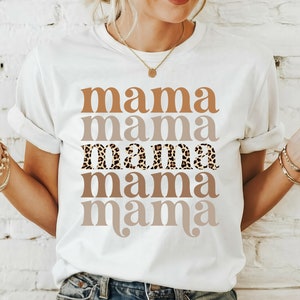 May include: White t-shirt with the word "mama" repeated five times in different shades of brown. The third "mama" is printed in a leopard print pattern.