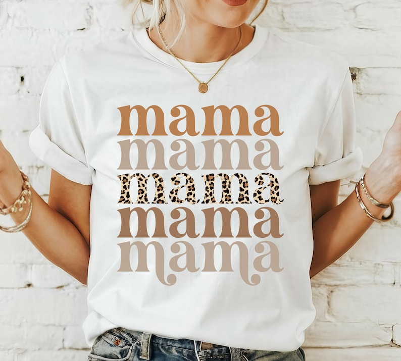 May include: White t-shirt with the word "mama" repeated five times in different shades of brown. The third "mama" is printed in a leopard print pattern.