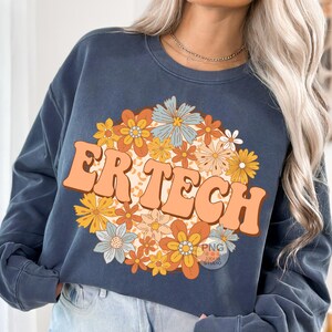 May include: A navy blue sweatshirt with a floral design and the text "ER TECH" in a retro font.