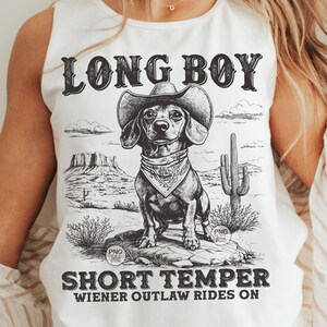 May include: White tank top with a black and white illustration of a dachshund wearing a cowboy hat and bandana. The text "Long Boy Short Temper Wiener Outlaw Rides On" is printed on the shirt.