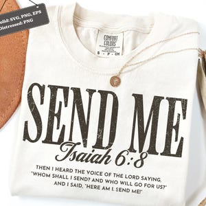 以下が含まれることがあります： 「SEND ME」の文字がかすれた黒文字でプリントされたクリーム色のTシャツ。 「イザヤ書6:8」と引用句も含まれています。 金色のネックレスがシャツの上に置かれています。 シャツには「Comfort Colors」のラベルが付いています。