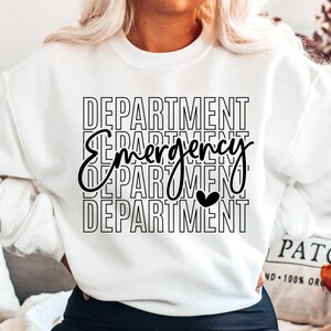 Może przedstawiać: Biała bluza z czarnym napisem "DEPARTMENT Emergency DEPARTMENT" z małym czarnym sercem w środku słowa "Emergency".