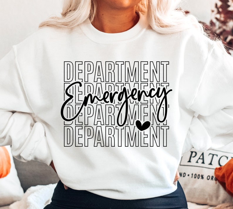 Może przedstawiać: Biała bluza z czarnym napisem "DEPARTMENT Emergency DEPARTMENT" z małym czarnym sercem w środku słowa "Emergency".