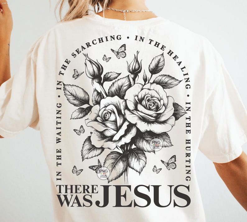 Peut inclure: Un t-shirt blanc avec un motif graphique noir repr&eacute;sentant un bouquet de roses et de papillons. Le texte "IN THE WAITING. IN THE SEARCHING. IN THE HEALING. IN THE HURTING. THERE WAS JESUS" entoure les roses.
