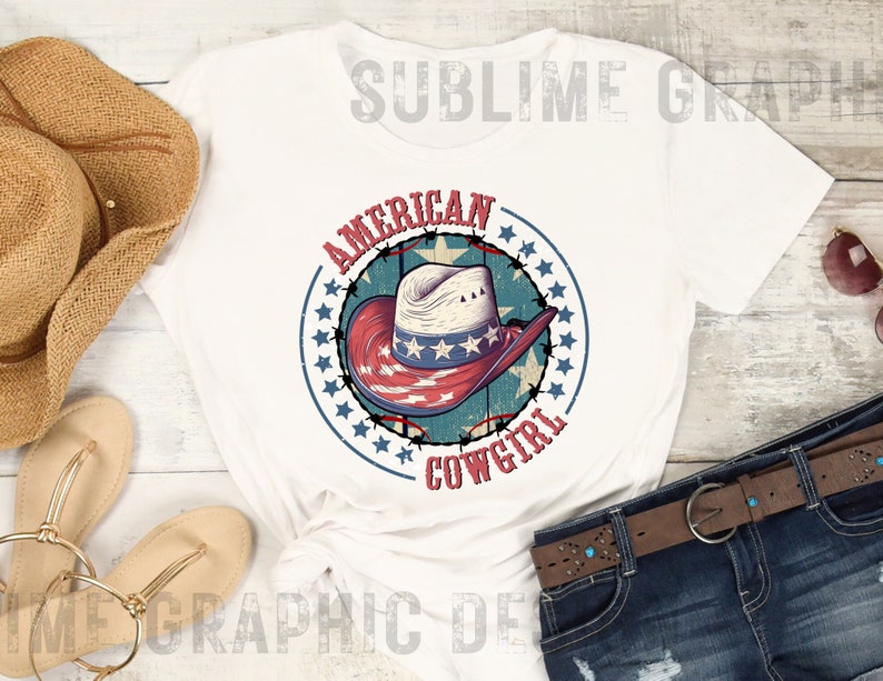 May include: White t-shirt with a red, white, and blue cowboy hat graphic. The graphic is surrounded by a circle of stars and the text "American Cowgirl".
