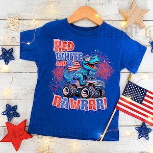 May include: A blue t-shirt with a red, white, and blue dinosaur monster truck design. The dinosaur is wearing sunglasses and holding an American flag. The text "Red White and Rawrrr!" is printed on the shirt.
