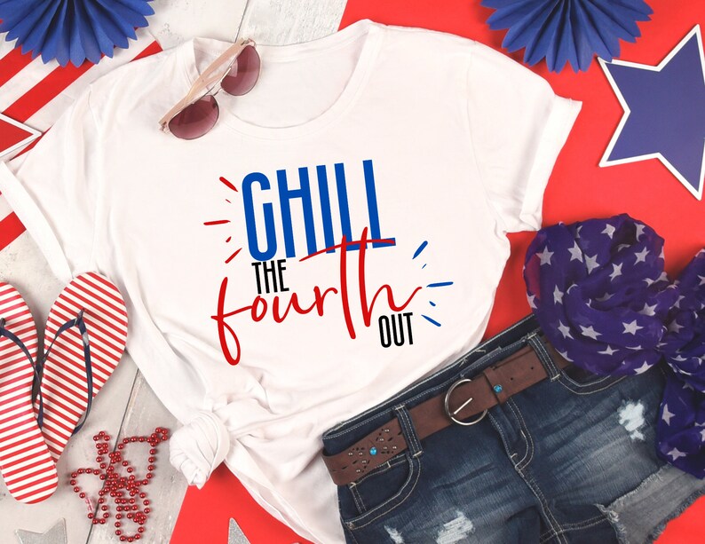 May include: White t-shirt with red, white, and blue text that says "Chill the Fourth Out". The shirt is laid out on a red, white, and blue background with a pair of sunglasses, a red and white striped flip-flop, and a blue and white star patterned scarf.