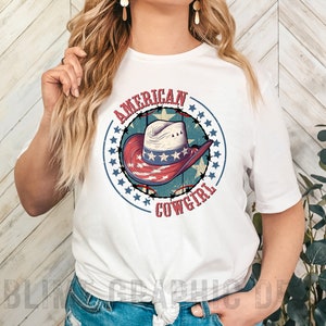 May include: White t-shirt with a red, white, and blue graphic of a cowboy hat with stars and the text "American Cowgirl".