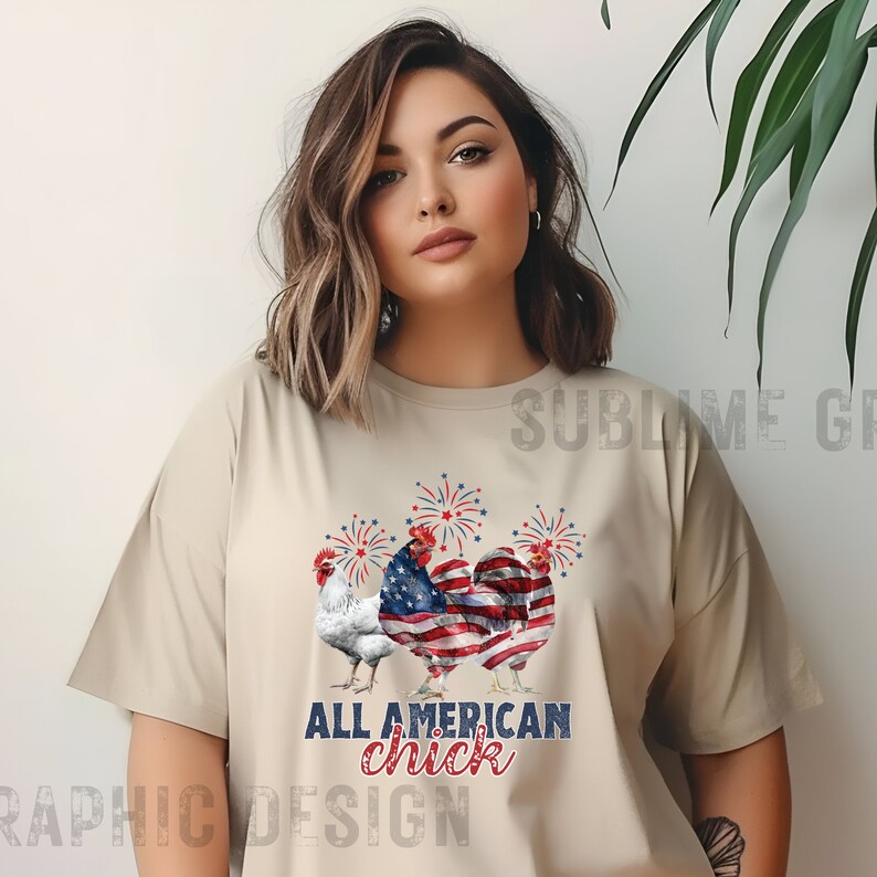 May include: Beige t-shirt featuring three rooster illustrations with patriotic American flag designs. The text "ALL AMERICAN chick" is printed below the roosters in blue and red. Fireworks are depicted above the roosters.