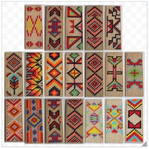 May include: A selection of rectangular woven bookmarks, each displaying a unique geometric pattern in vibrant colours. The designs incorporate red, yellow, blue, and orange against a beige backdrop. The bookmarks are arranged in neat rows.