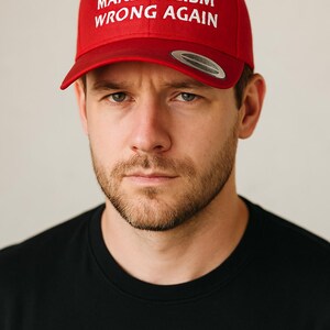 May include: A red baseball cap with the text "MAKE RACISM WRONG AGAIN" in white lettering.