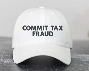 May include: White baseball cap with black text that reads "COMMIT TAX FRAUD".