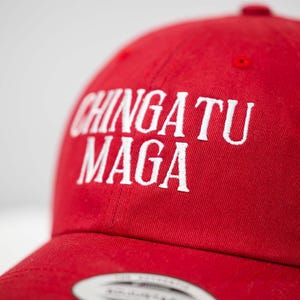 May include: Red baseball cap with white embroidered text that reads "CHINGATU MAGA".
