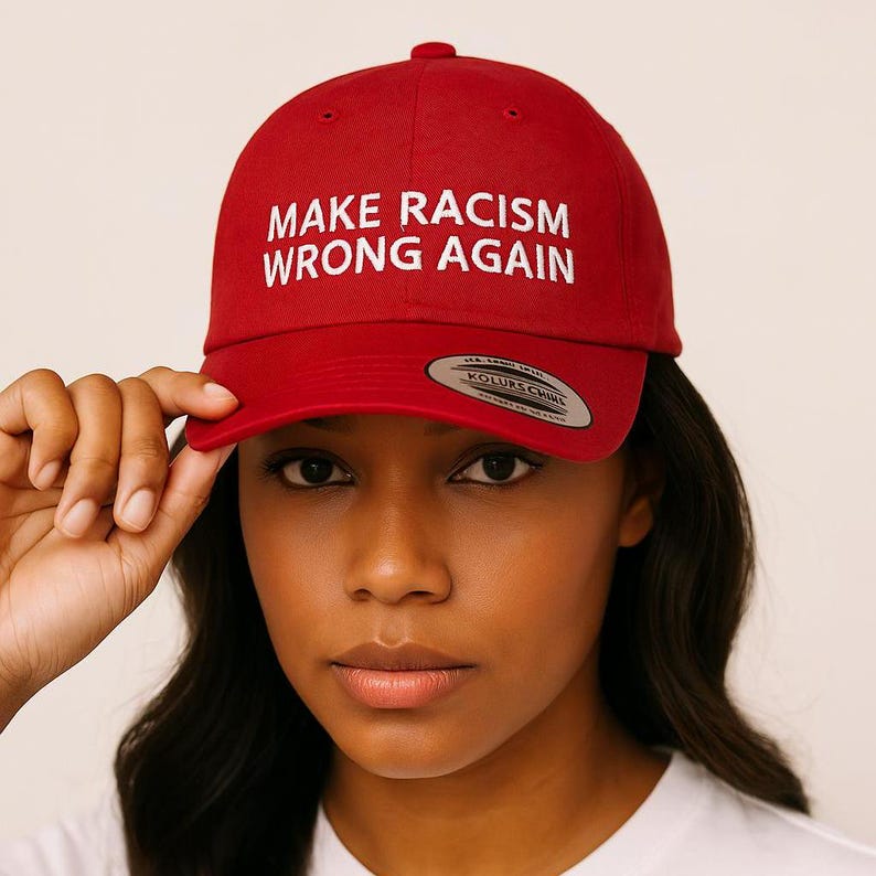 May include: Red baseball cap with a white embroidered message that reads "Make Racism Wrong Again".