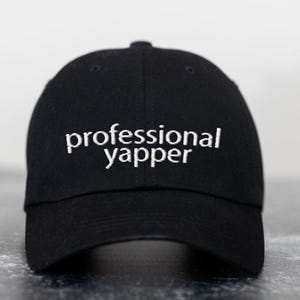 May include: A black baseball cap with white embroidery that reads "professional yapper".