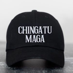 May include: A black baseball cap with the text "CHINGATU MAGA" embroidered in white.