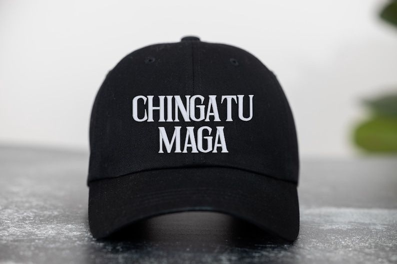 May include: A black baseball cap with the text "CHINGATU MAGA" embroidered in white.