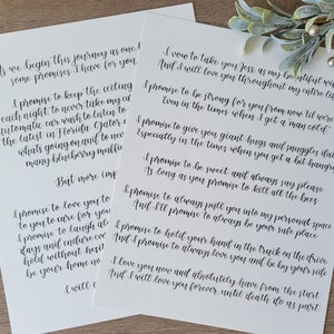 May include: Two white sheets of paper with handwritten vows in black ink. The vows are written in cursive script. The paper is on a light-colored surface. The vows are for a wedding.