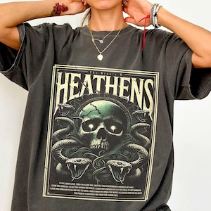 May include: An oversized t-shirt in dark grey with a graphic print of a skull with snakes and the text "The King's Heathens".